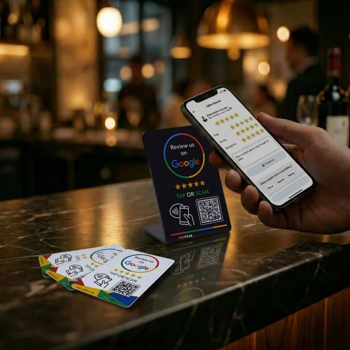 TapFive Google Review Stand and Cards on restaurant counter with phone showing 5-star review